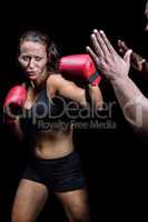 Female fighter hitting on trainer hand