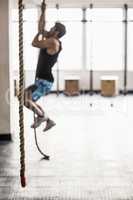 Young Bodybuilder climbing the ropes