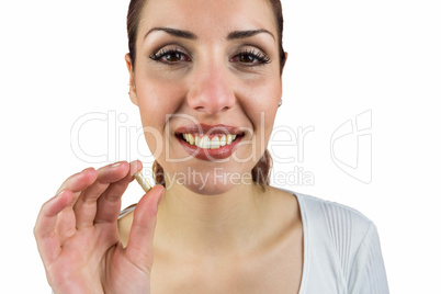 Portrait of smiling woman holding pill