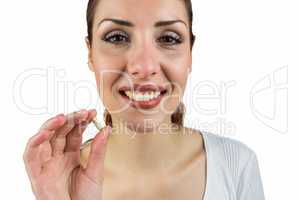 Portrait of smiling woman holding pill