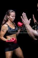 Female boxer hitting on trainer hand