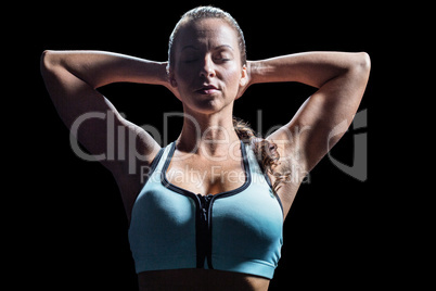 Sporty woman relaxing with hands behind head