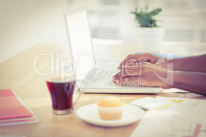 Cropped hands working on laptop at desk