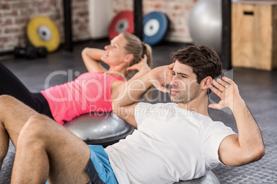 Fit couple doing abdominal crunches