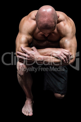 Bodybuilder kneeling down