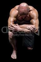 Bodybuilder kneeling down