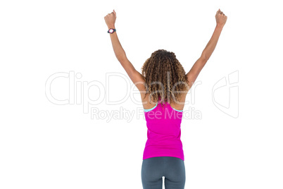 Rear view of young woman cheering with arms raised