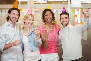 Colleagues holding champagne flute in birthday party
