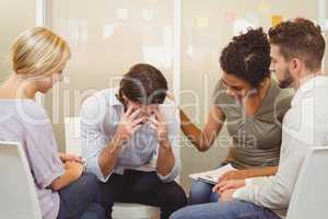Business people consoling businessman suffering from headache