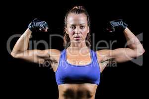 Portrait of woman with gloves flexing muscles
