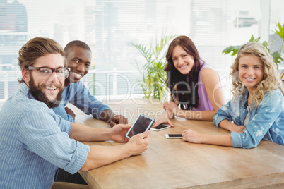 Portrait of smiling business professionals using technology at d