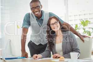 Smiling business professionals working at computer desk