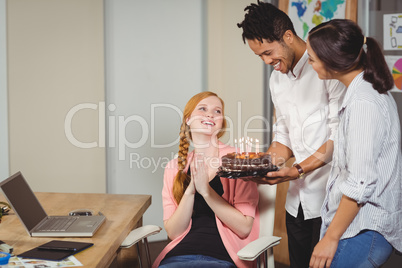 Business people celebrating birthday of colleague