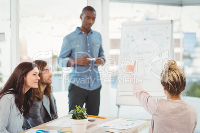 Rear view of woman with hand raised while discussing with cowork