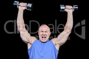 Muscular man with arms raised lifting dumbbells
