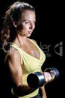 Confident pretty woman lifting dumbbells