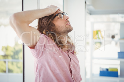 Side view of tired hipster with hand on head