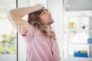 Side view of tired hipster with hand on head