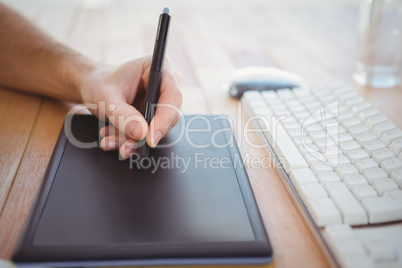 Cropped hand of man using graphics tablet