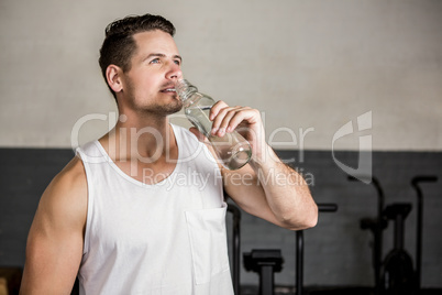 Muscular man holding bottle
