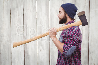 Side view of hipster with axe on shoulder