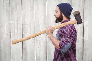 Side view of hipster with axe on shoulder