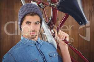 Portrait of hipster carrying bicycle