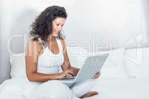 Beautiful smiling pregnant woman using laptop