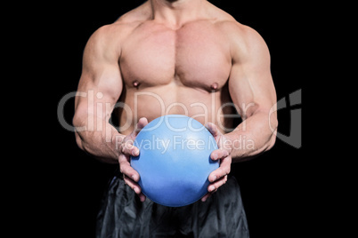 Midsection of bodybuilder exercising with ball