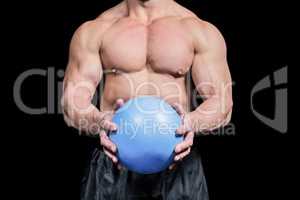 Midsection of bodybuilder exercising with ball