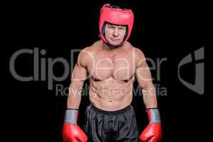 Portrait of shirtless man with boxing headgear and gloves