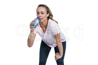 Tired sporty woman bending and drinking water