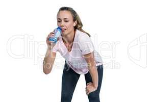 Tired sporty woman bending and drinking water