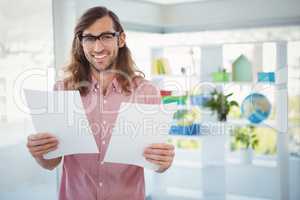 Portrait of happy hipster holding documents