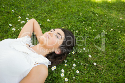 Woman relaxing with hand behind head on grassland