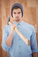 Portrait of serious hipster holding axe on shoulder