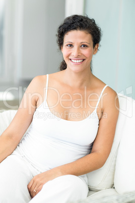 Portrait of happy woman sitting on lounge sofa