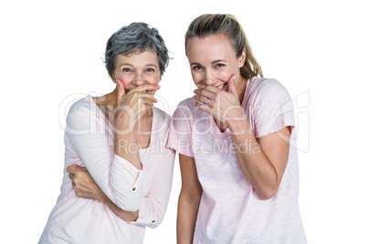 Mother and daughter laughing with hand on mouth