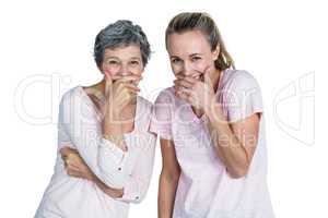 Mother and daughter laughing with hand on mouth