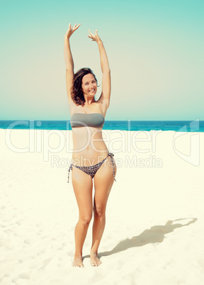 woman raised her hands up on the beach