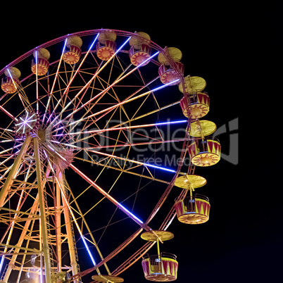 Ferris wheel with lights backlighting the night sky