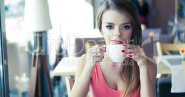 Smiling Young Woman Drinking Coffee in Sunny Cafe