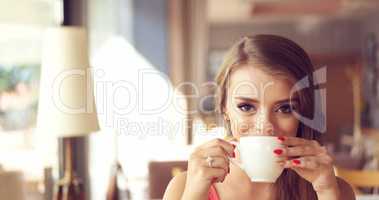 Smiling Young Woman Drinking Coffee in Sunny Cafe