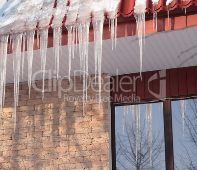 icicles on building roof at winter day