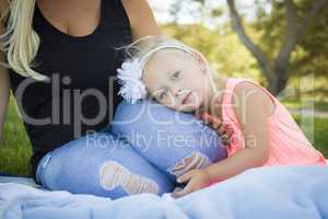 Beautiful Young Girl Resting on Her Mommy's Lap At Park