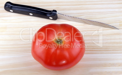 wood kitchen board with knife and tomato