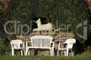 Gartenszene mit Möbeln und Hundeskulptur