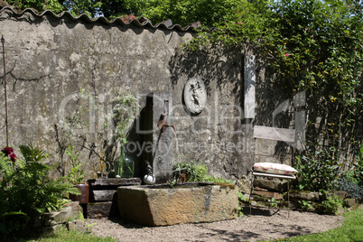 Gartenecke mit Stuhl und Brunnen