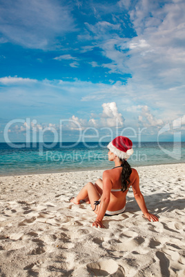 Woman in santa hat on the beach