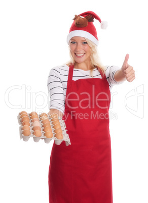 Weihnachtsfrau hält eine Palette mit Eiern und zeigt Daumen hoch